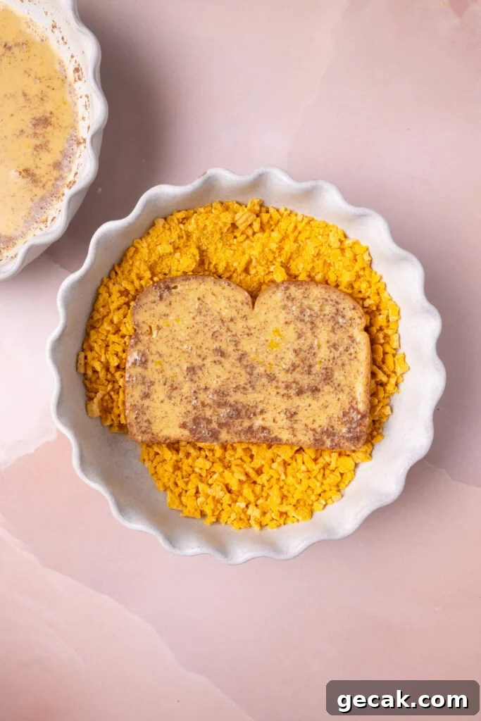 25-Minute Crunchy Cap'n Crunch French Toast Recipe 11 Pushing bread with egg wash into crushed Cap'n Crunch to coat.