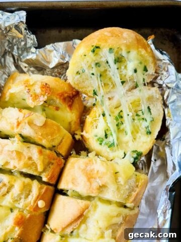 Close up of strechy cheesy garlic bread straight out of the oven