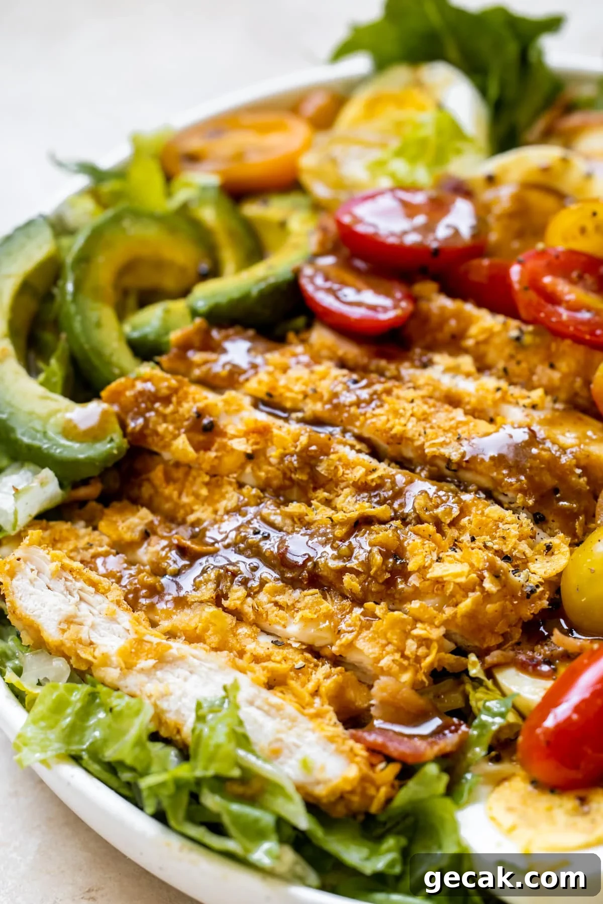 an up close image on balsamic dressing on crispy chicken on a salad. 