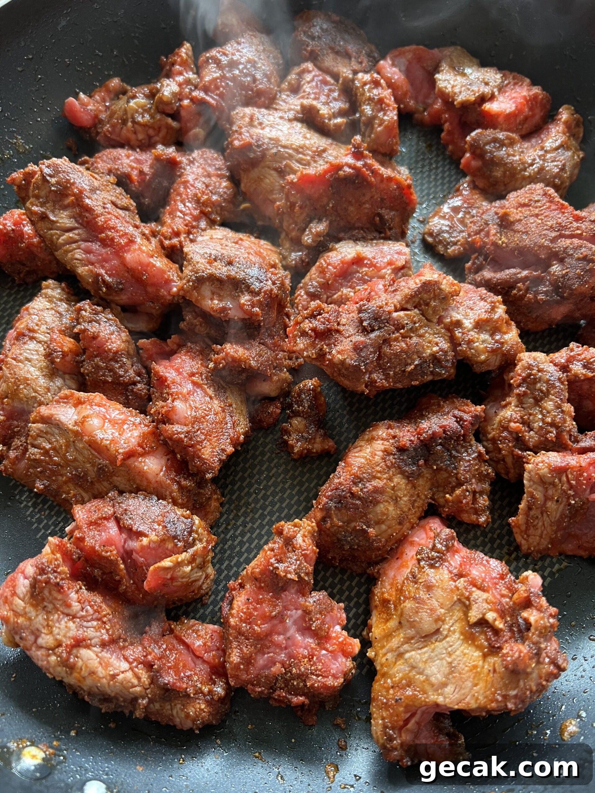 Seared meat in frying pan.