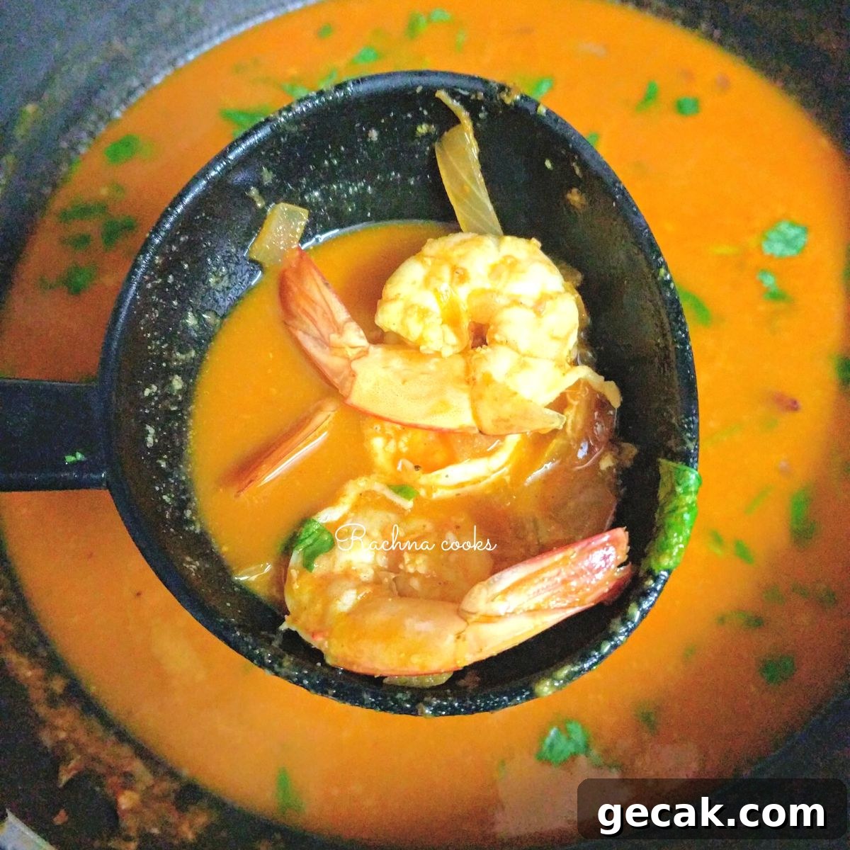 Authentic Goan Prawn Curry Recipe for Coconut Lovers 2 Prawn curry held up in ladle with two prawns visible