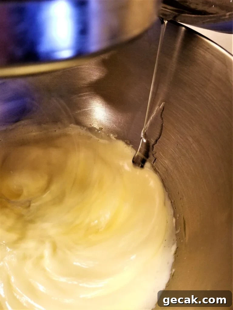 pouring sugar syrup into the egg yolks