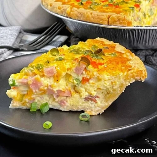 A slice of Western Omelet Quiche on a dark plate.