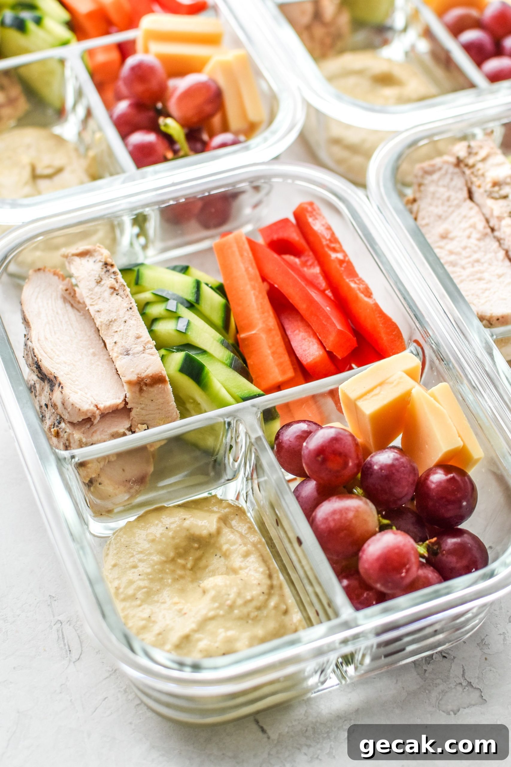 A Chicken & Hummus Plate Lunch Meal Prep with chicken, veggies and hummus ready to be eaten for lunch.