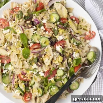 Gluten-free pasta salad with tomatoes, cucumber, pine nuts, herbs, and more.