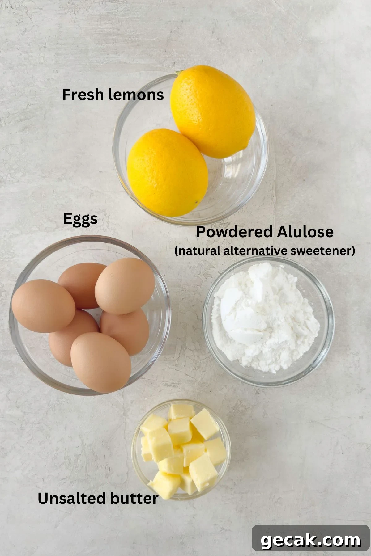 Simple ingredients for  sugar-free lemon curd, lemon, sugar, eggs, unsalted butter, on a counter.