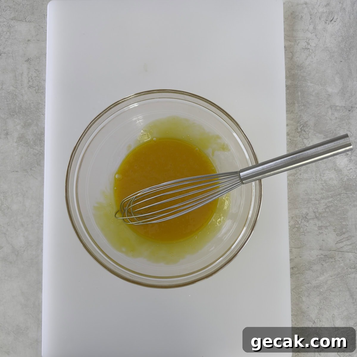 Bright golden yellow egg yolks whisked together in a glass bowl.