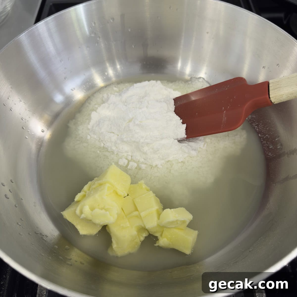 A stainless steel pan with lemon juice, butter, and allulose sugar.