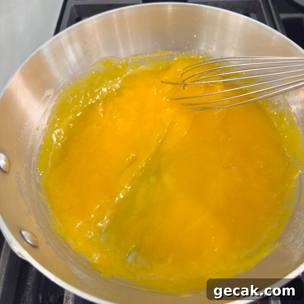 Thickened, cooked lemon curd ready to be strained from the pan.