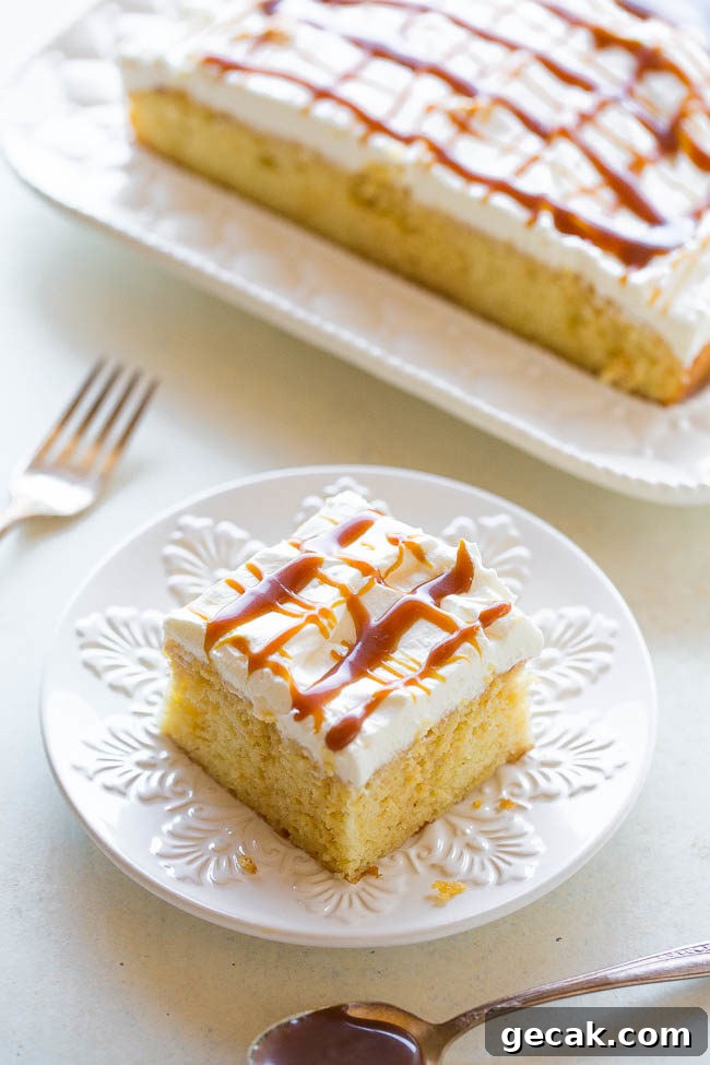 Piece of caramel cream poke cake on a white plate
