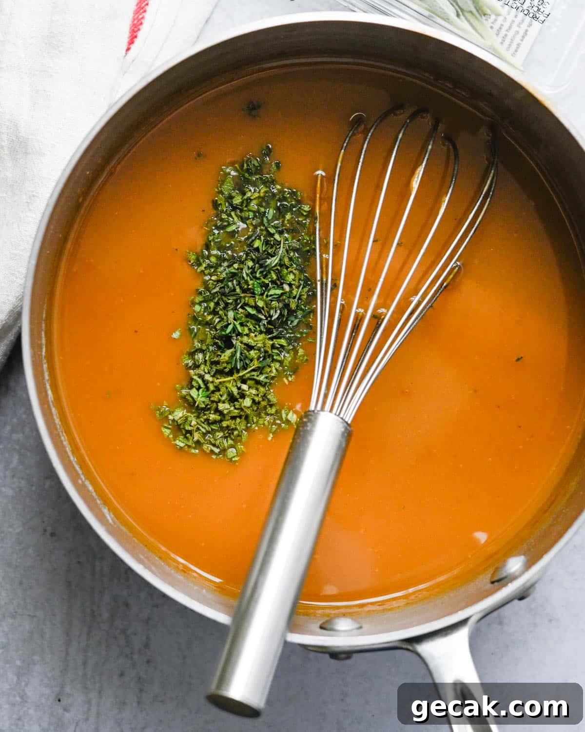 Adding fresh herbs to the turkey gravy.