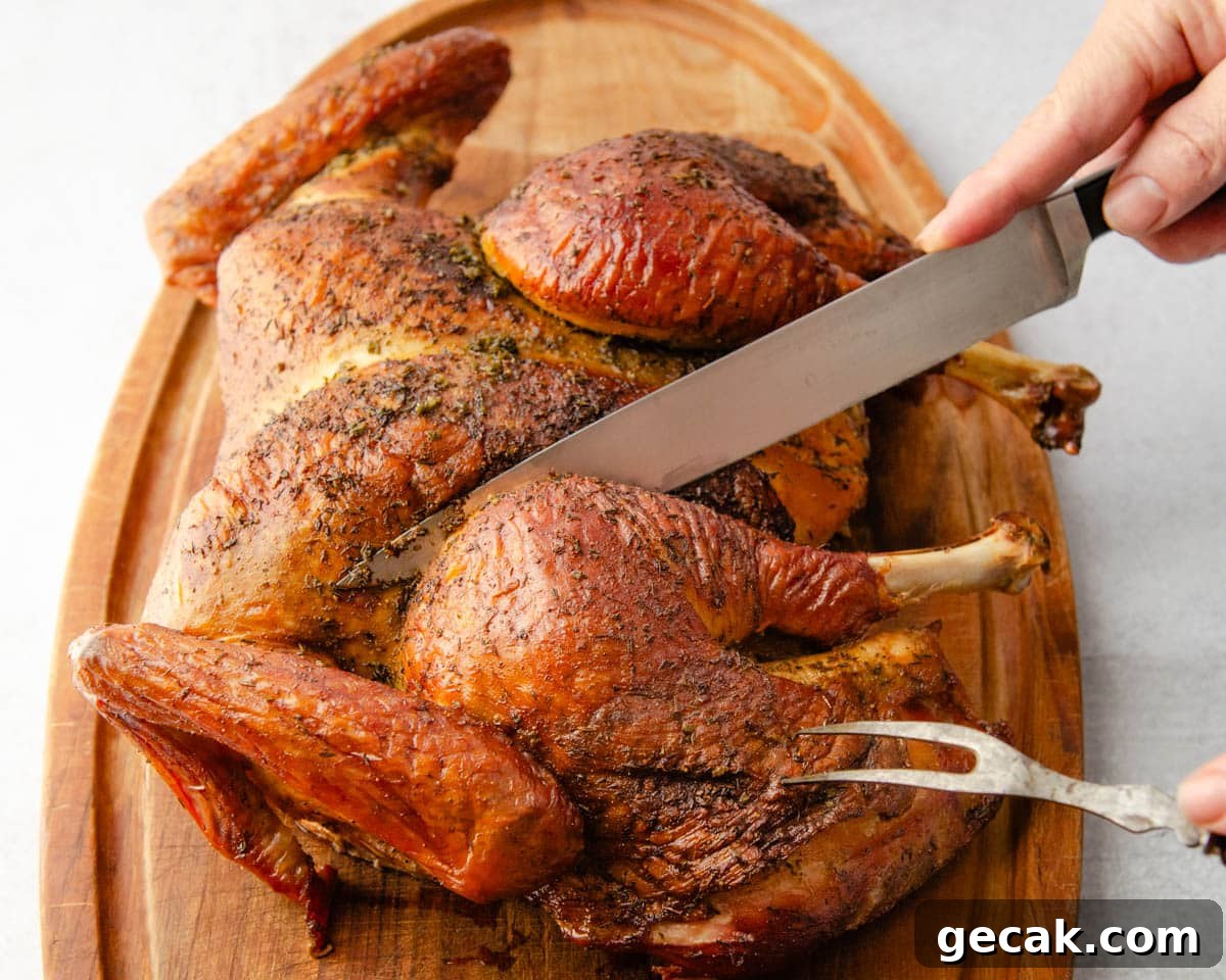 Carving the grilled turkey on a cutting board.