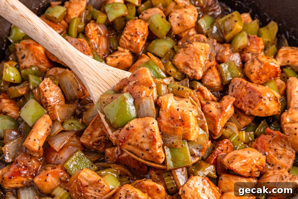 wooden spoon scooping black pepper chicken