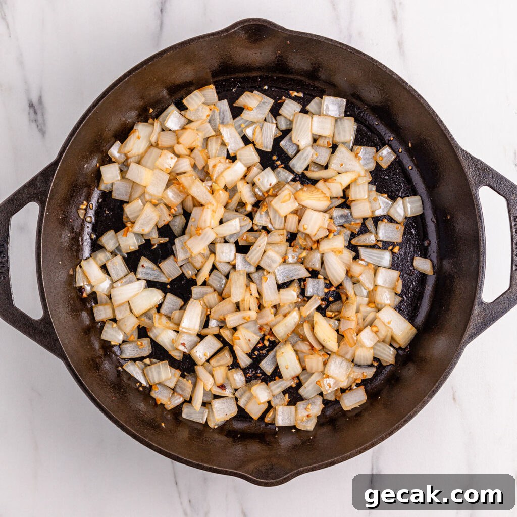 onions cooking in cast iron pan for black pepper chicken