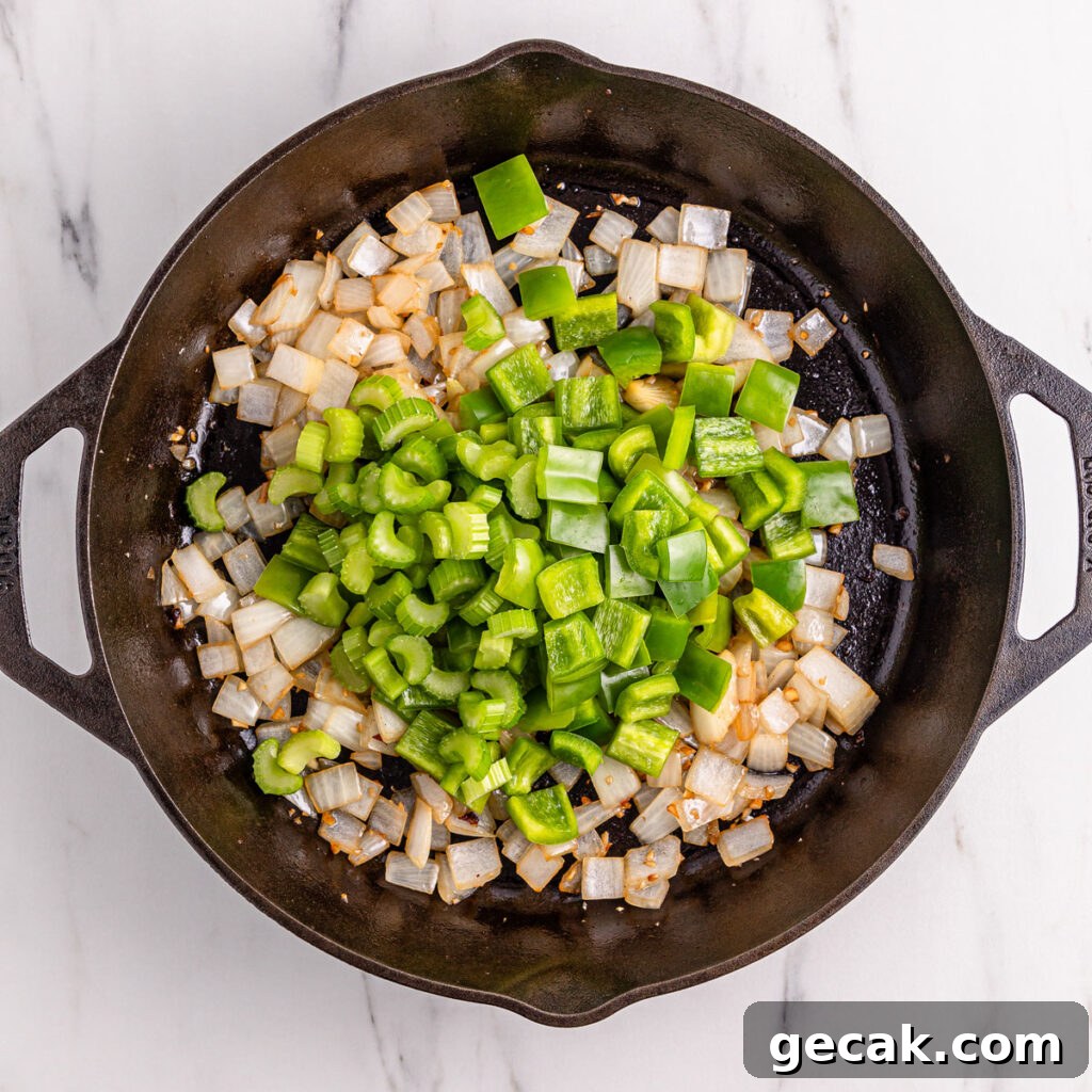 chopped onion and bell pepper in cast iron skillet for black pepper chicken