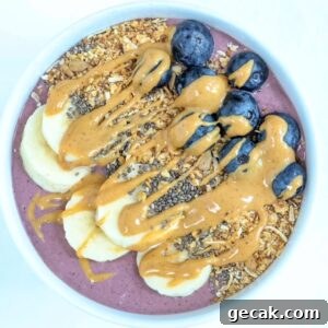 One acai protein bowl topped with toppings served in a white bowl.