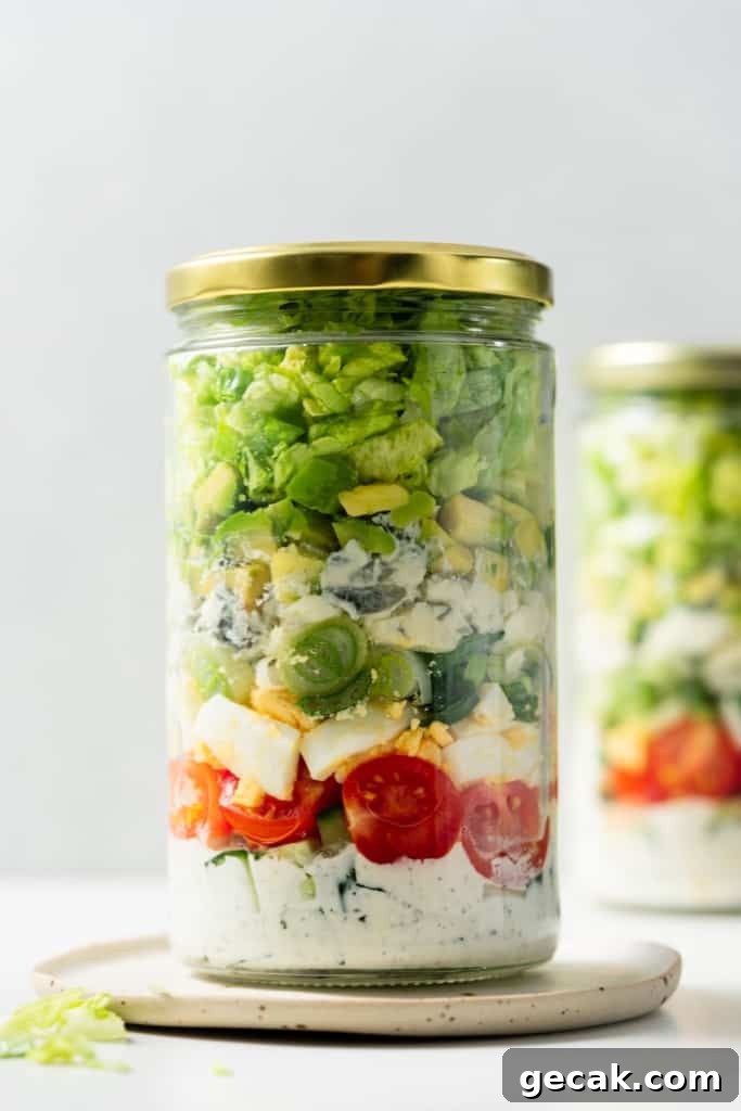 Vegetarian Cobb salad stored in a glass jar with a gold lid.