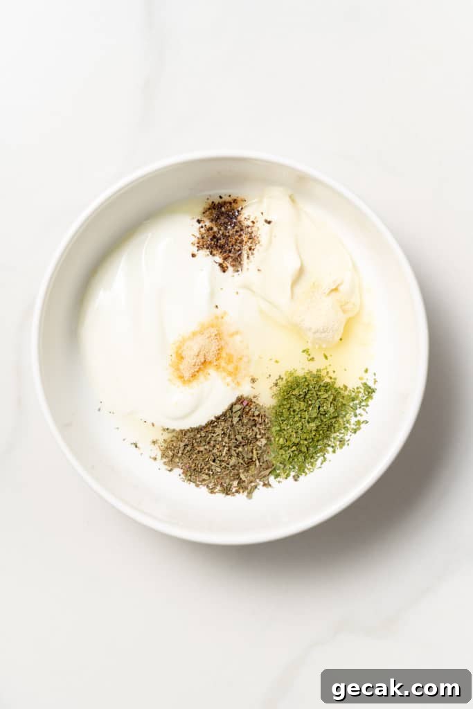 Mayo, Greek yogurt and seasonings added to a white bowl.