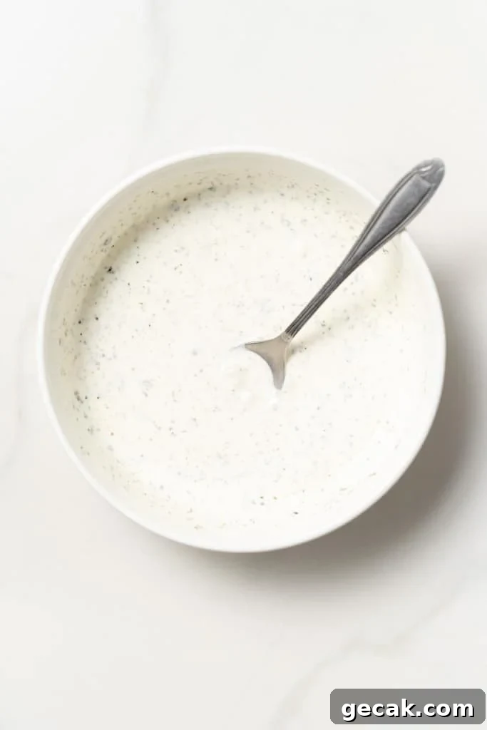 Whisking homemade ranch dressing in a bowl.