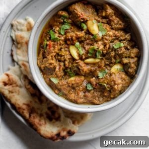 Pakistani Beef Curry (Stew) in a bowl on top of a plate with naan