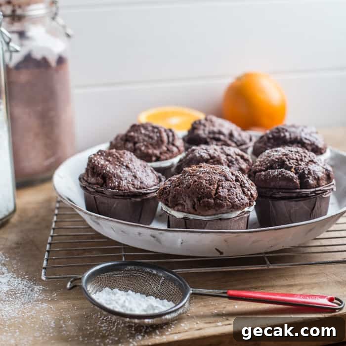 Chocolate Orange Muffins Recipe with Zesty Dark Chocolate Swirls 9 White plate with 7 chocolate orange muffins on, surrounded by baking items
