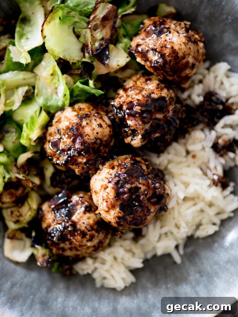 sticky sweet chicken meatballs in a bowl with rice and brussels sprouts