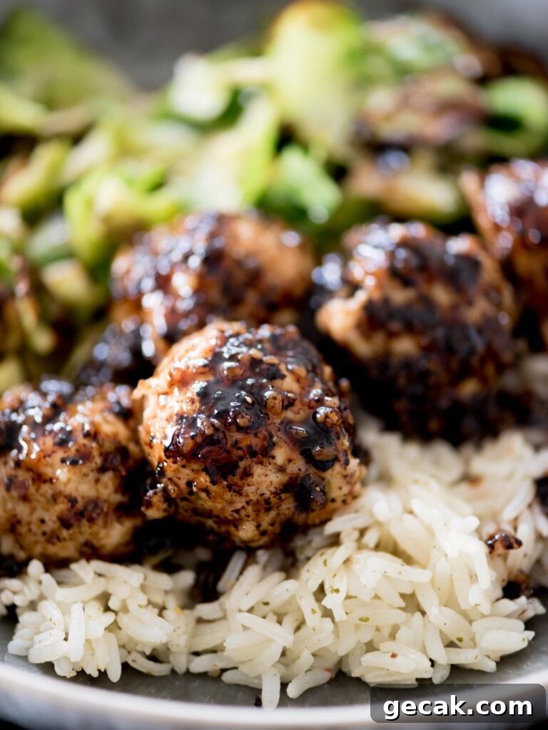 sticky sweet chicken meatballs in a bowl with rice and brussels sprouts