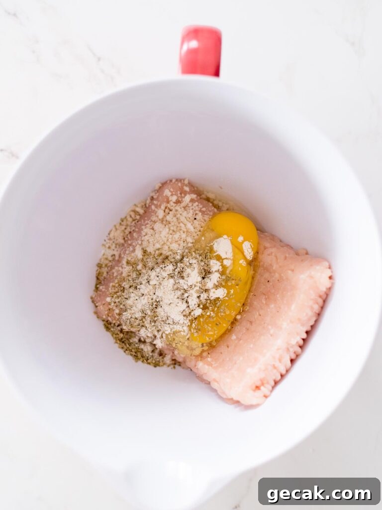 all ingredients for chicken meatballs in a bowl, unmixed