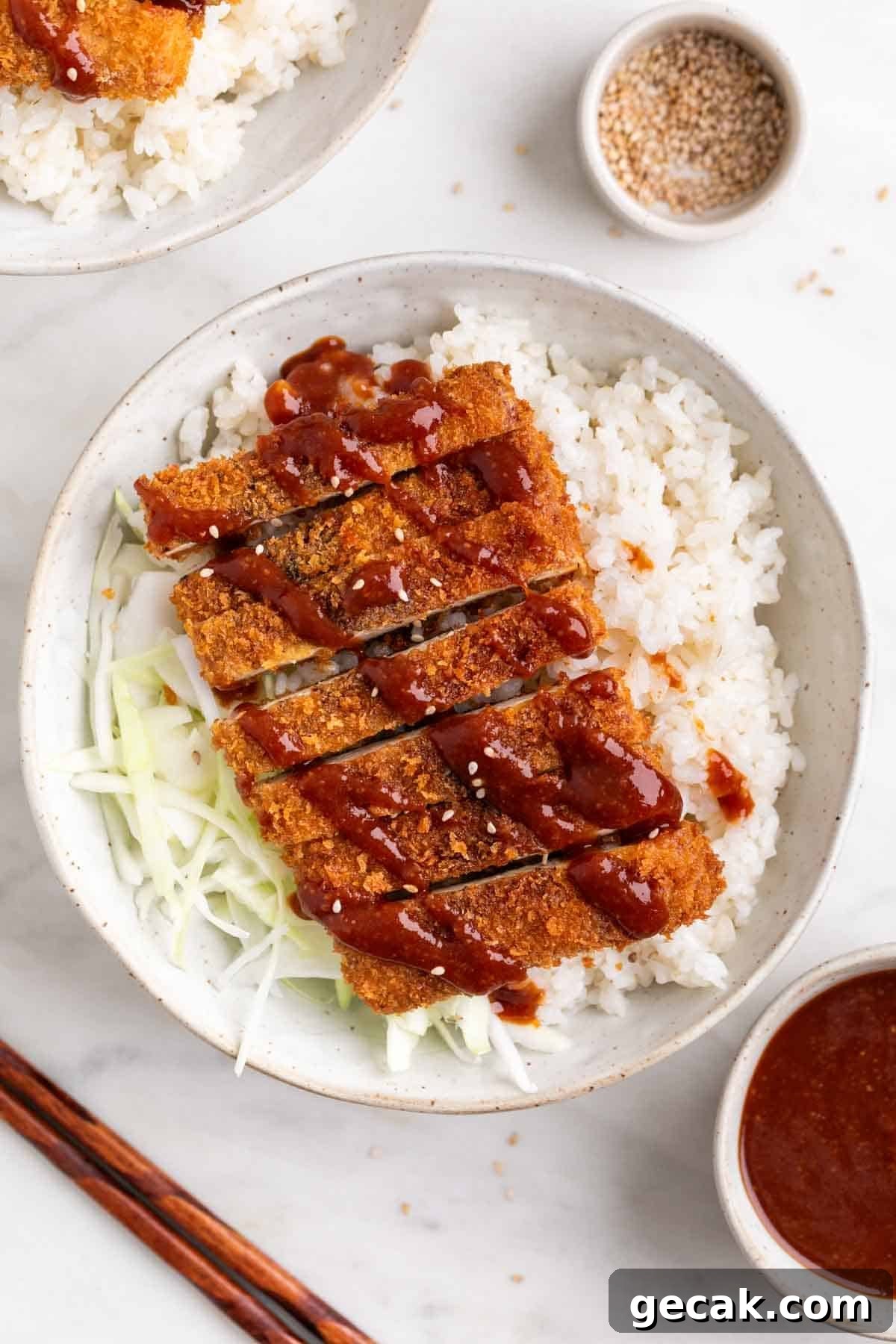 Japanese-style tofu katsu bowl with rice, cabbage, and sesame seeds.