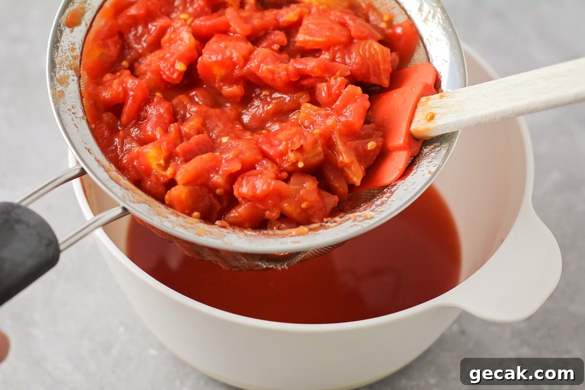 Crushed tomatoes being drained in bowl.