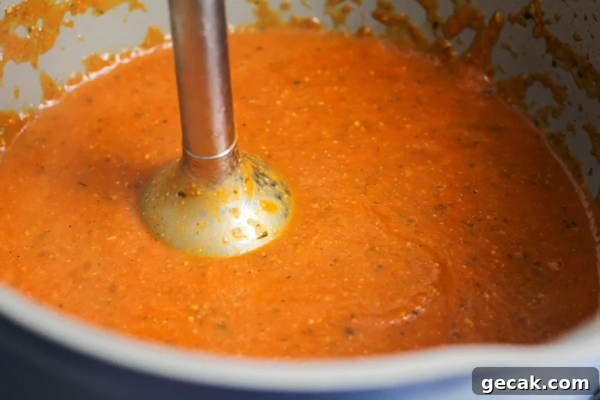 Creamy tomato basil soup in pot.