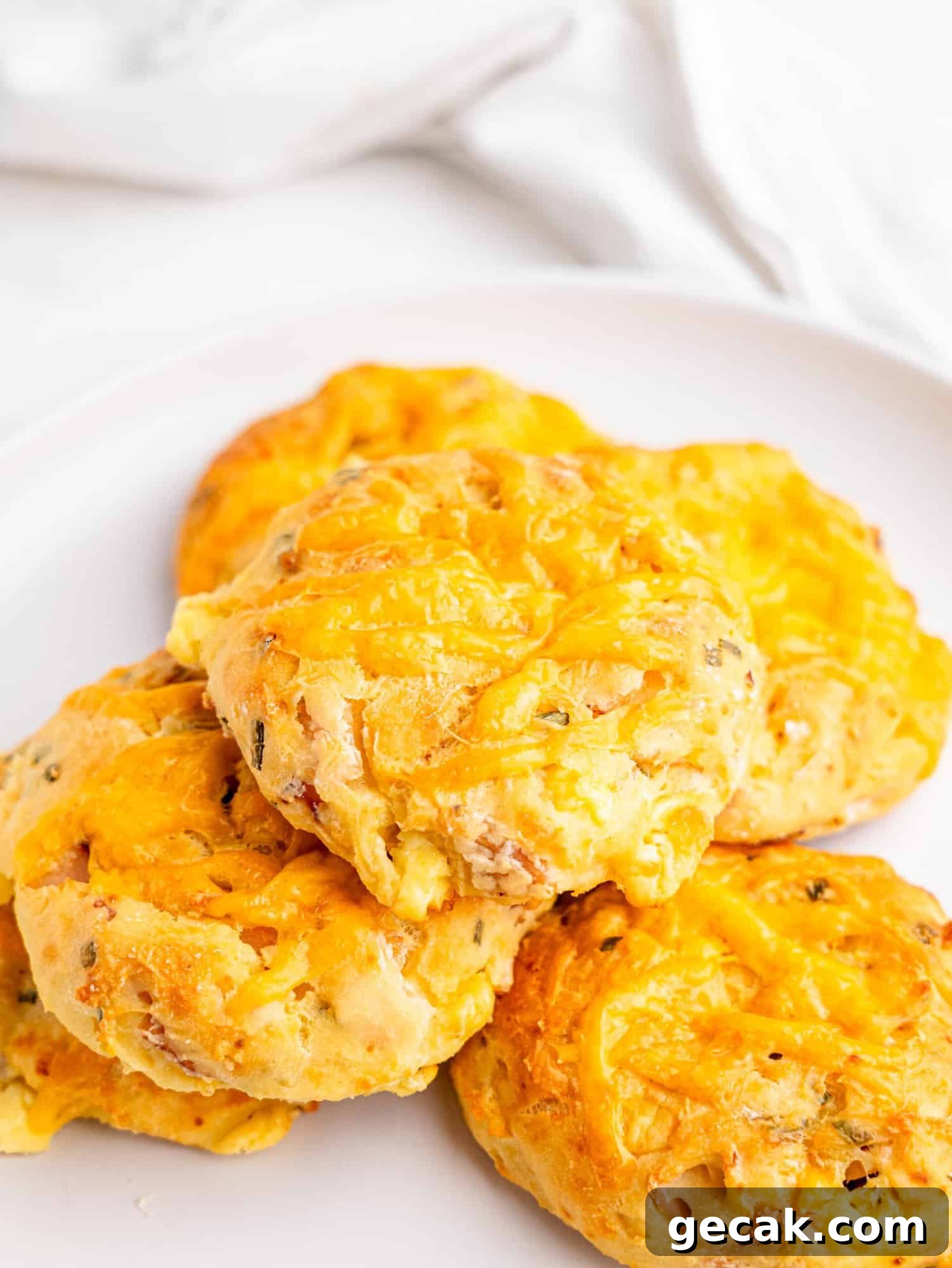High-Protein Biscuits Without Butter — Fluffy, Low-Fat Recipe 2 Protein biscuits with ham and cheese on a white plate.