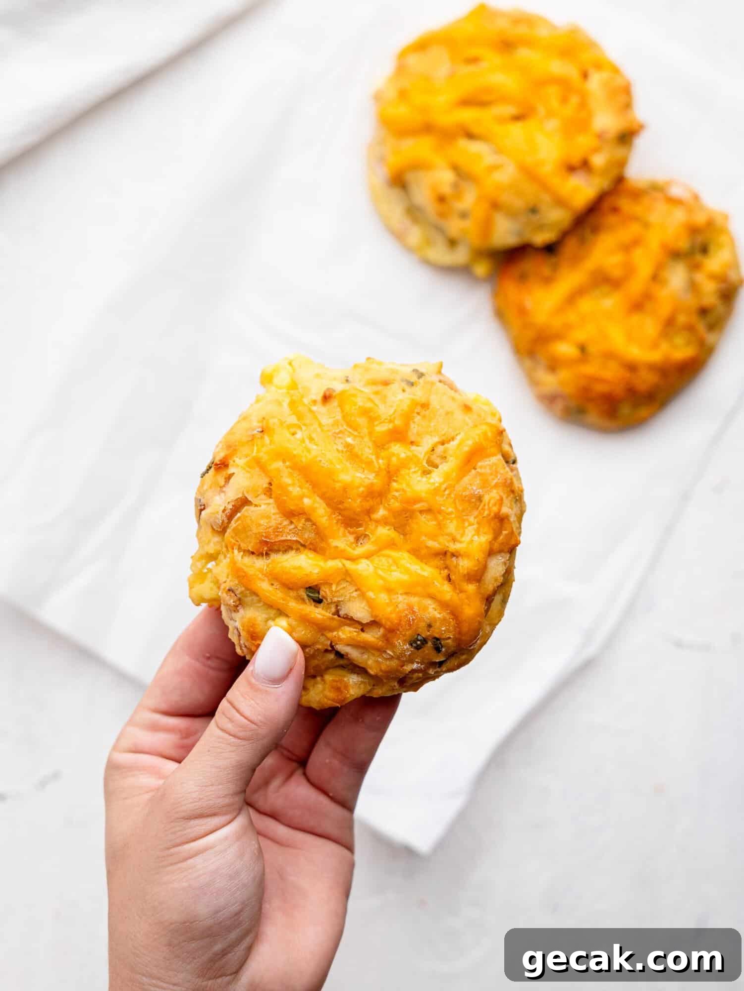 High-Protein Biscuits Without Butter — Fluffy, Low-Fat Recipe 4 A hand holding a breakfast biscuit.