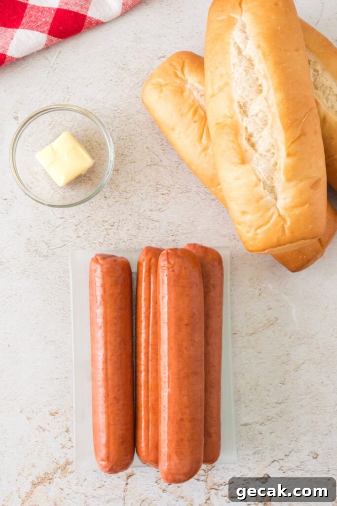 Crispy Air Fryer Hot Dogs: Quick, Juicy, and Ready in Minutes 3 Raw hot dog sausages, hoagie buns, and a pat of butter on a light countertop