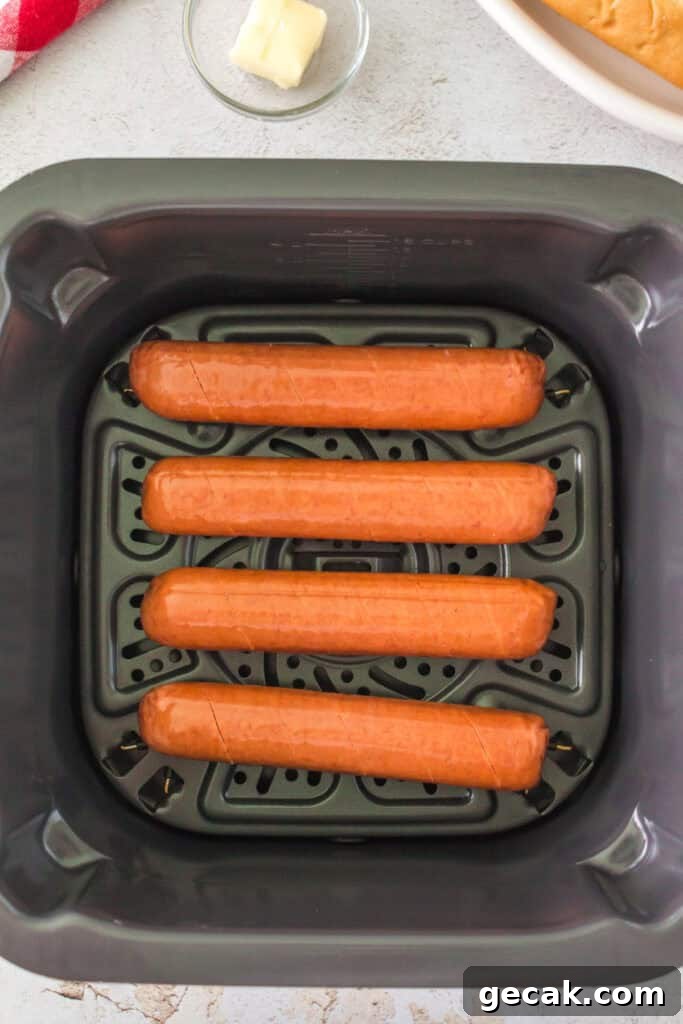 Crispy Air Fryer Hot Dogs: Quick, Juicy, and Ready in Minutes 5 Four raw scored hot dog sausages placed in an air fryer basket