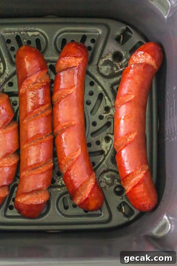 Crispy Air Fryer Hot Dogs: Quick, Juicy, and Ready in Minutes 6 Hot dogs halfway cooked, skin starting to crisp inside air fryer