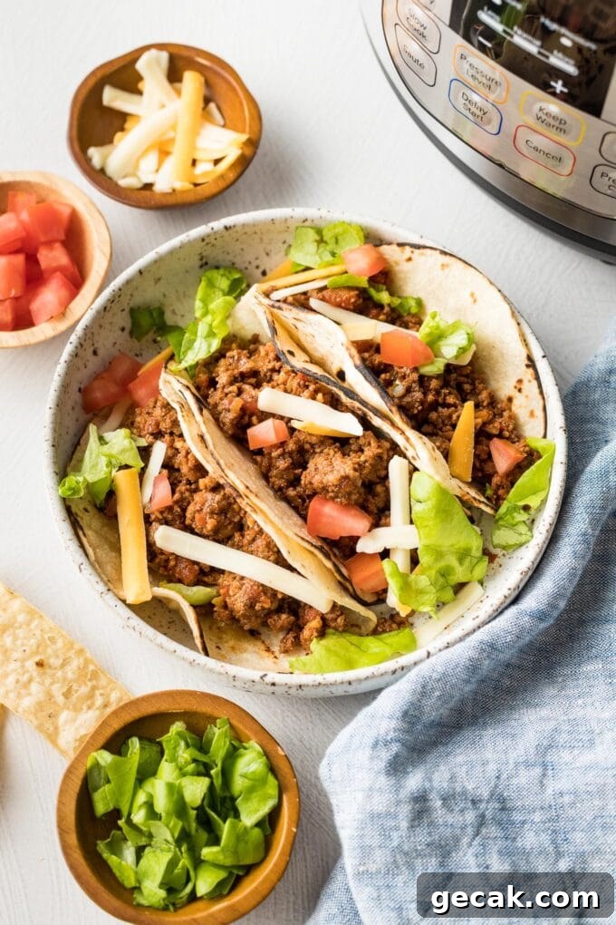 Plate with ground beef tacos and Instant Pot in the background.