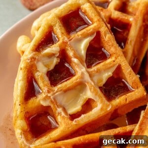 Eggnog waffles tipped with butter and drizzled with a homemade cinnamon syrup.