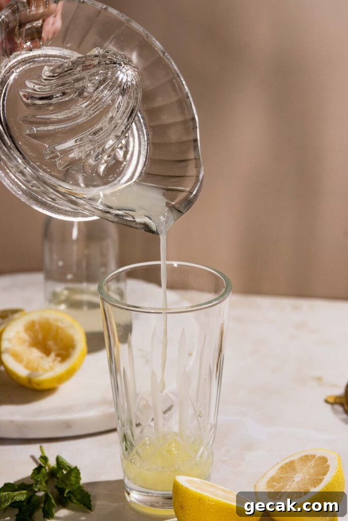 Lemon juice being poured into a cocktail shaker. 