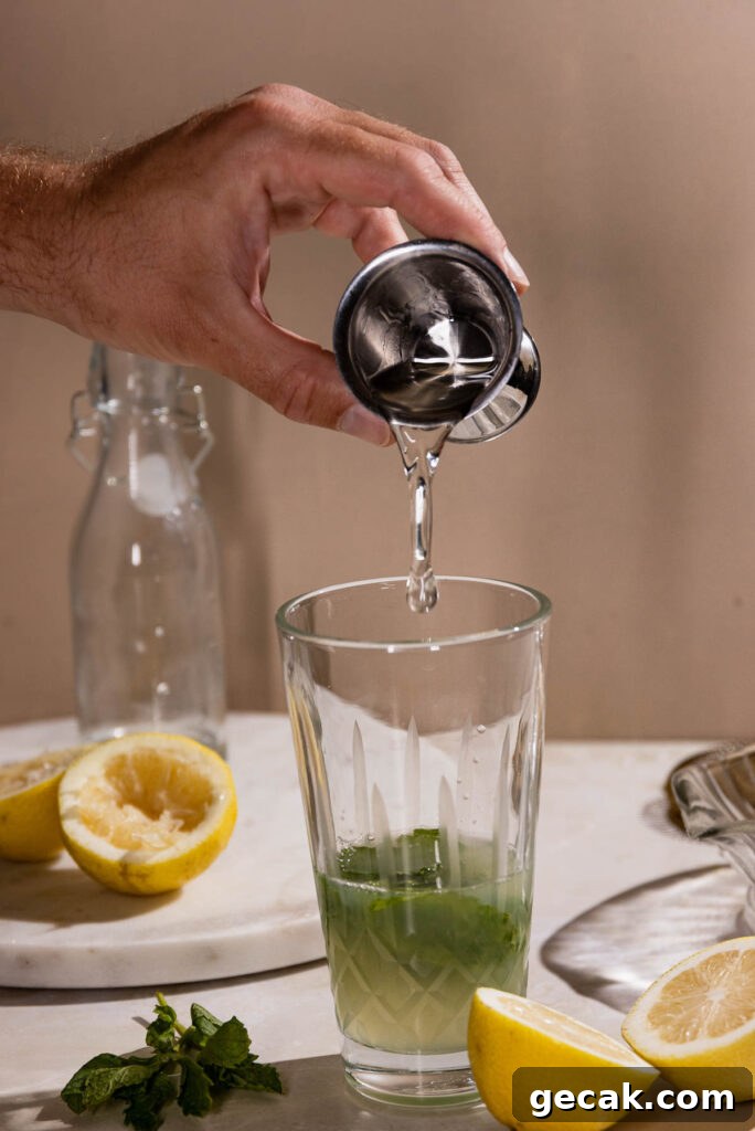Gin being added to a cocktail shaker. 
