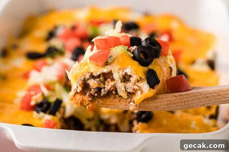 Taco Casserole being served on a wooden spoon.