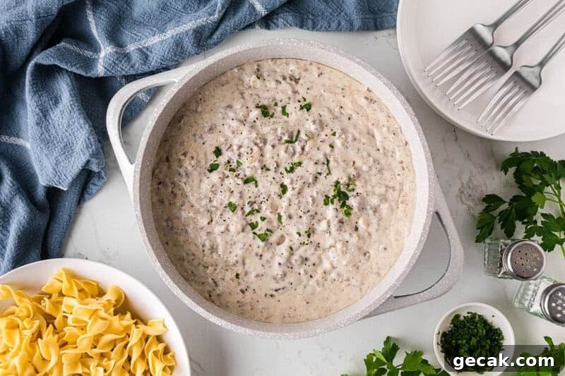 ground beef stroganoff served in a large white pot.
