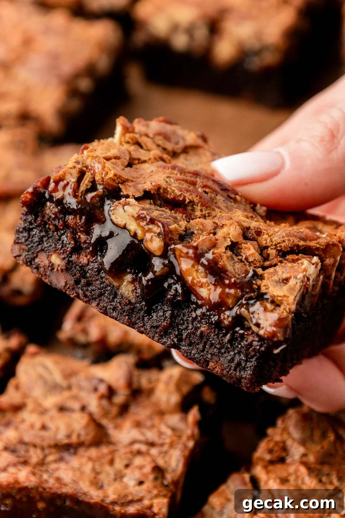 Close up of pecan pie brownies in a woman's hand.