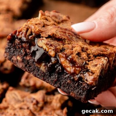 Close up of pecan pie brownies in a woman's hand.