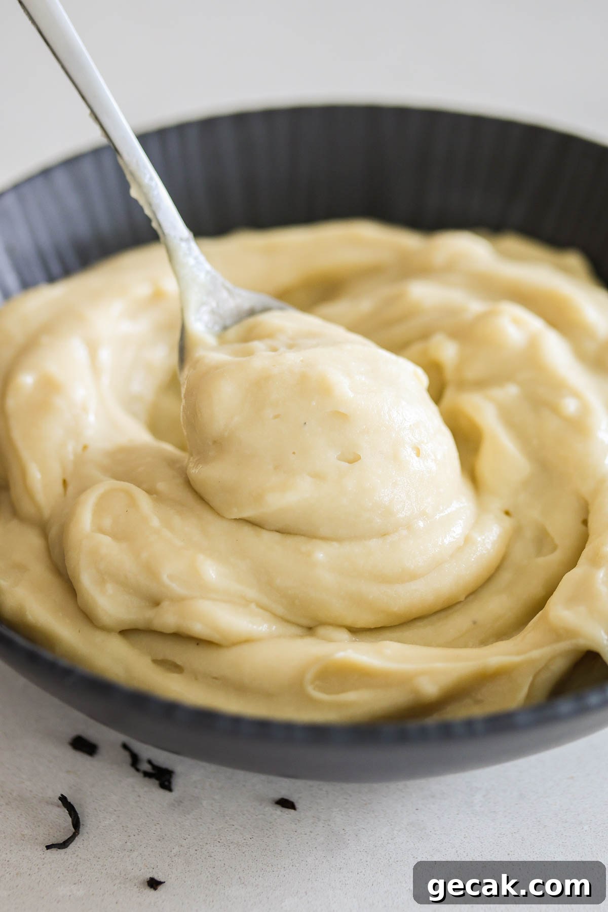 Earl Grey custard in a black bowl with spoon.