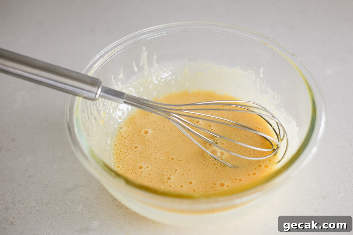 Mixture in a glass bowl with whisk.