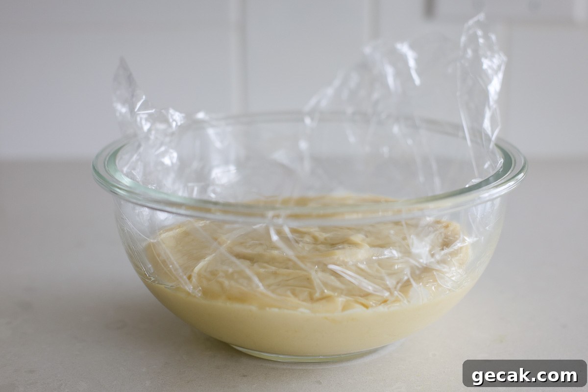 Custard in a glass bowl covered with plastic film.