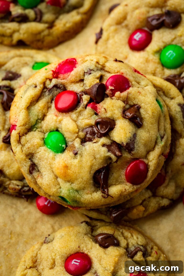 a photo of a large chocolate chip cookies with red and green Christmas m&m's in it.