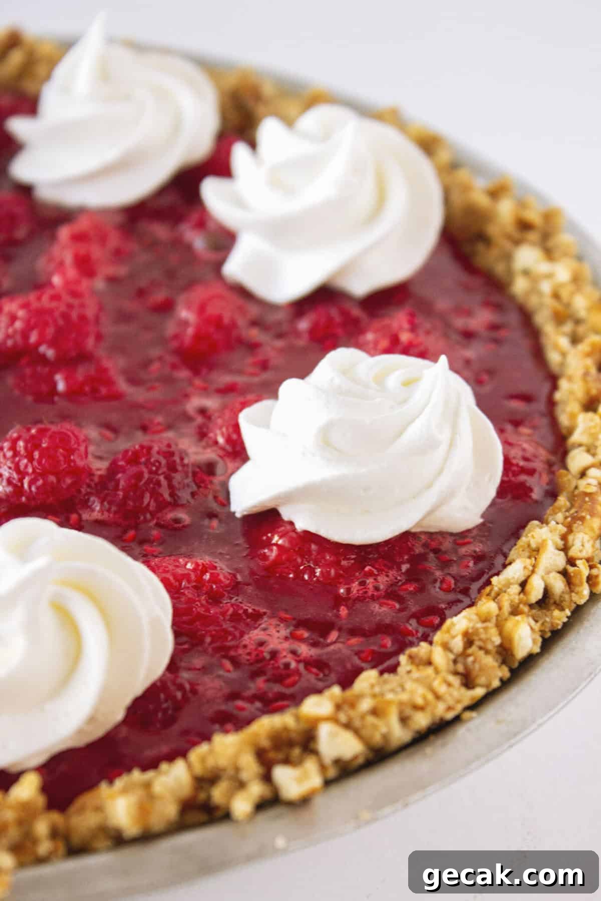 A raspberry pretzel pie with cheesecake filling and whipped cream.