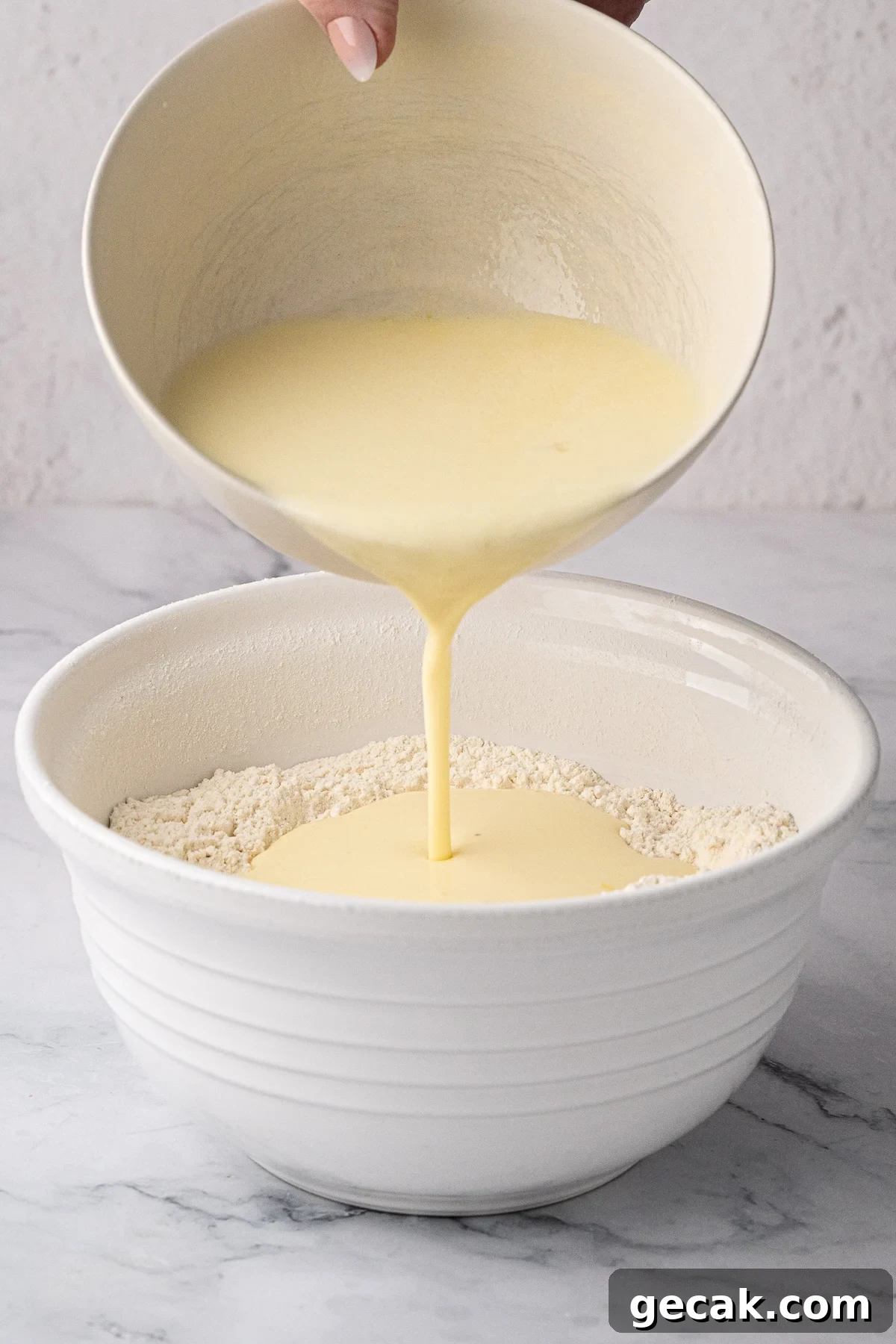 Creating a well in the center of dry flour ingredients before slowly adding the buttermilk mixture.